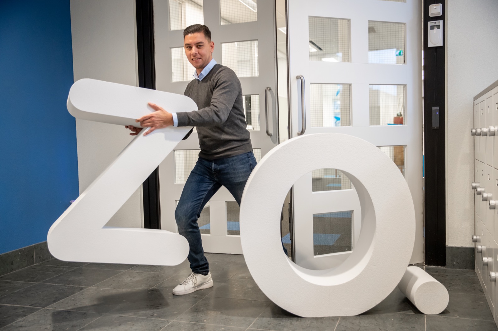 Medewerker draagt de ZO-letters bij de entree