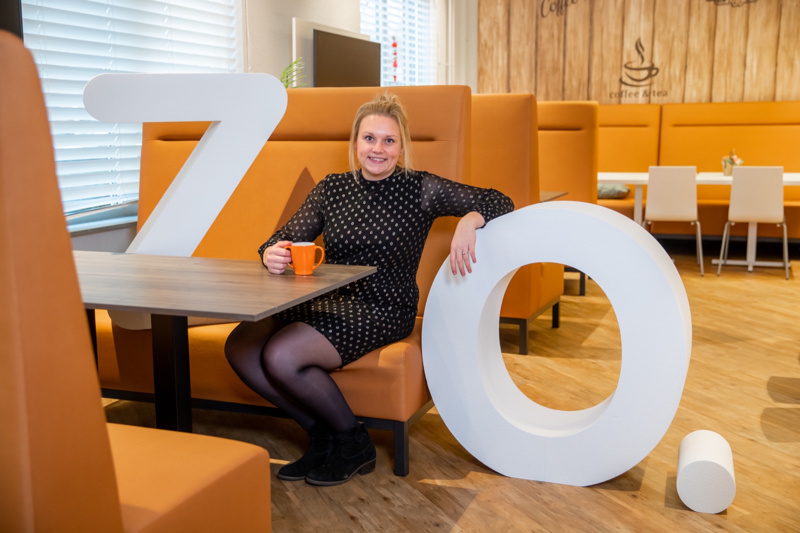 Medewerker met koffie en de ZO-letters in de kantine