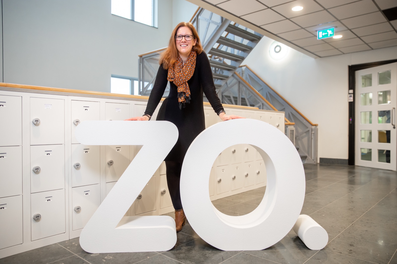 Medewerker poseert met grote ZO-letters bij de lockers